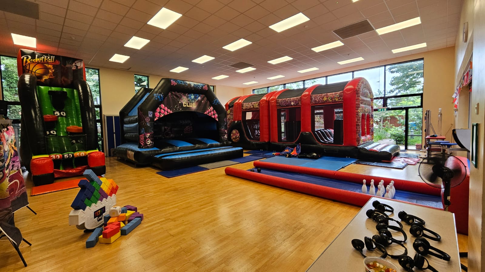 Bouncy castles and party equipment set up inside an indoor venue